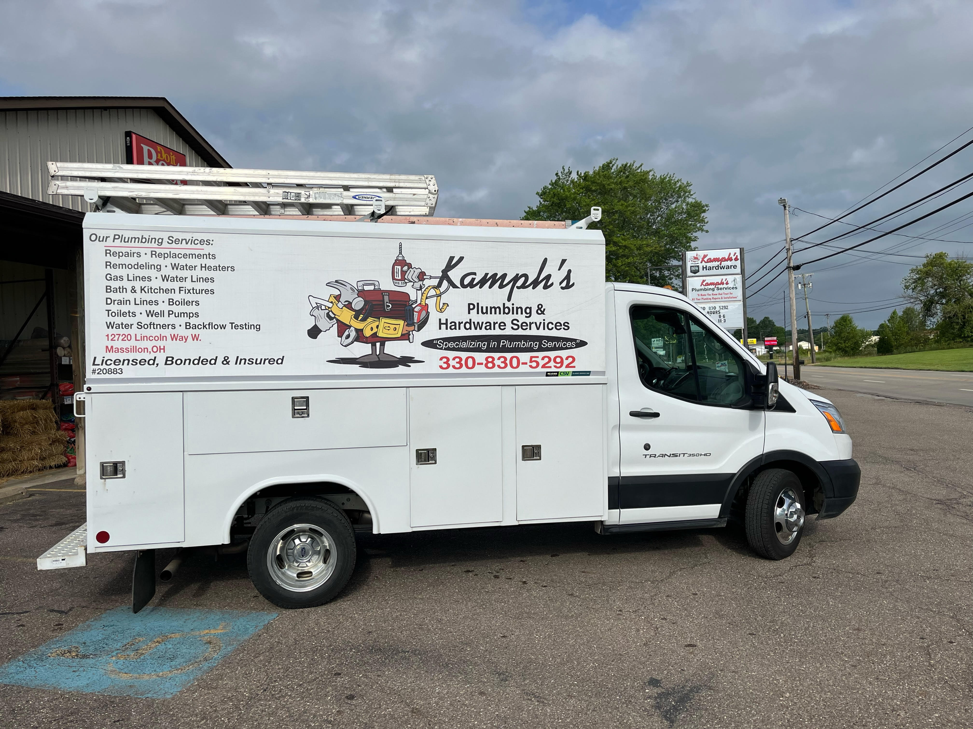 A white utility truck is parked on the side of the road.