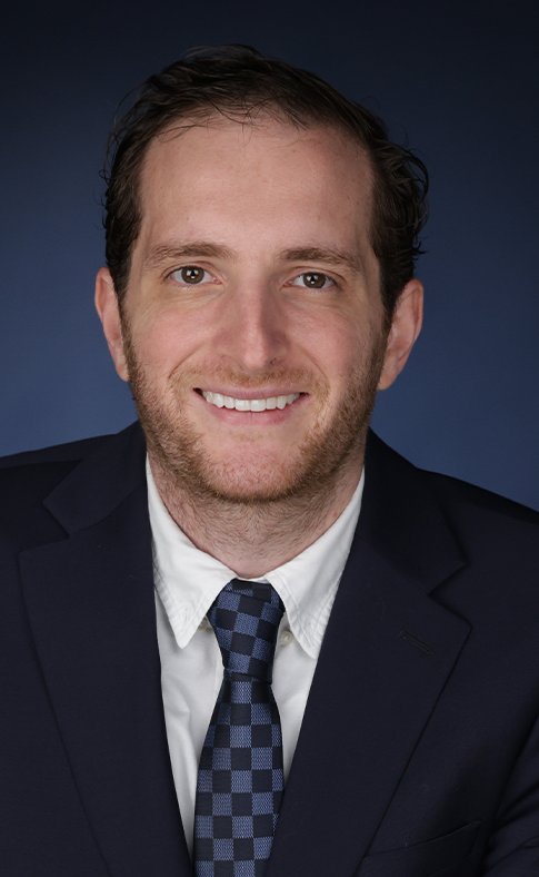 Um homem de terno e gravata está sorrindo para a câmera.