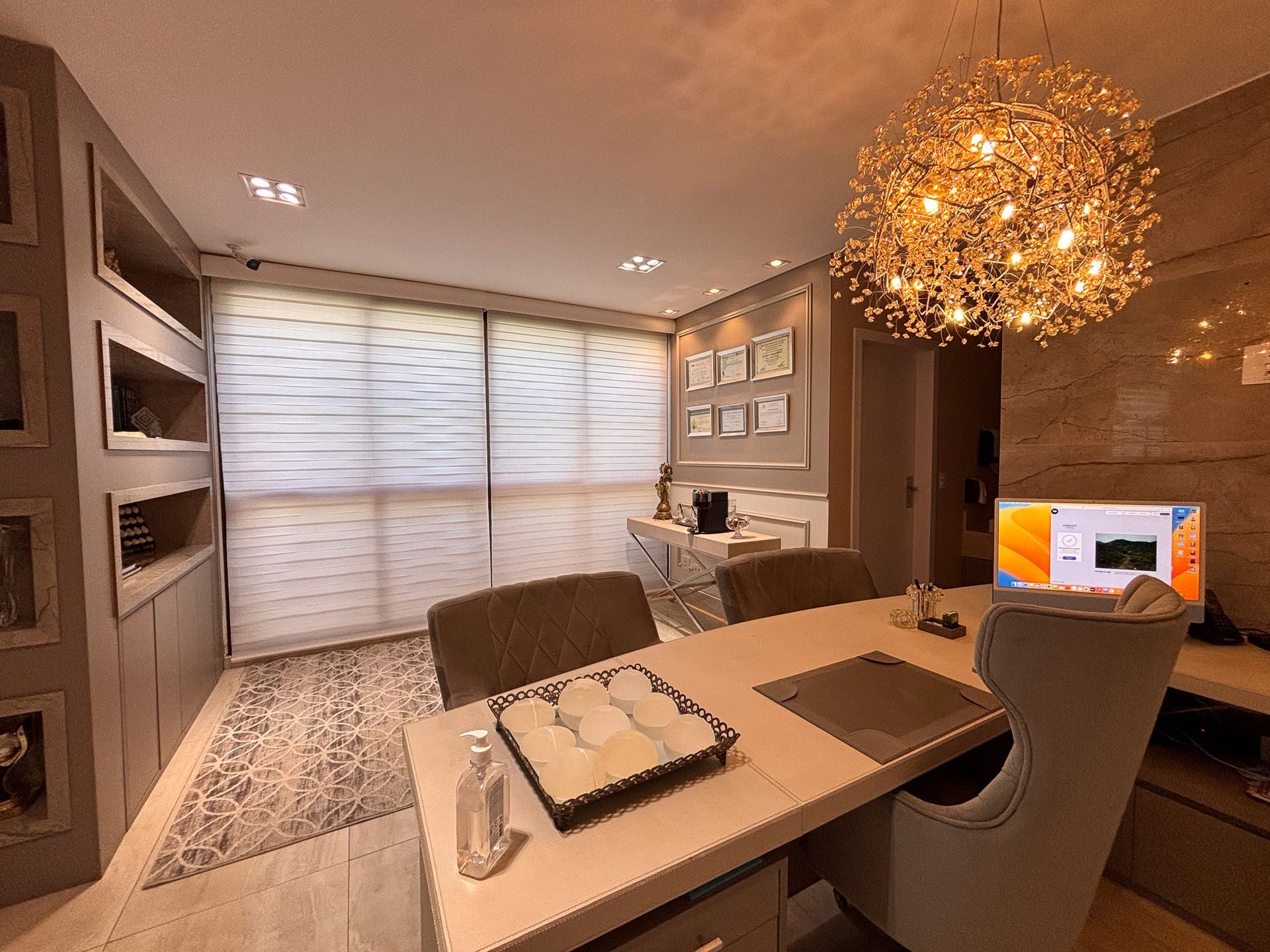 Uma sala de estar com uma mesa, cadeiras e um lustre.