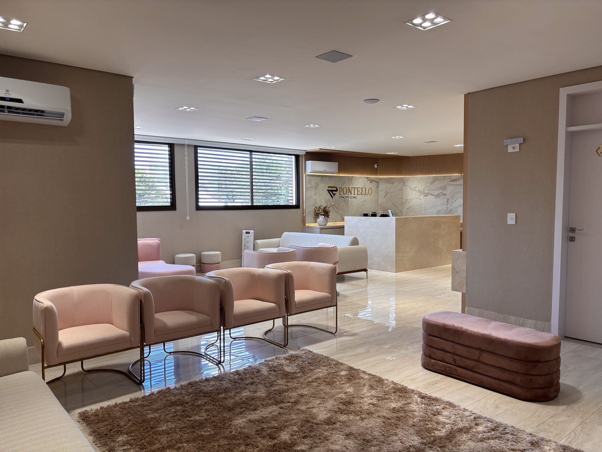 Uma sala de espera com muitas cadeiras e um tapete.