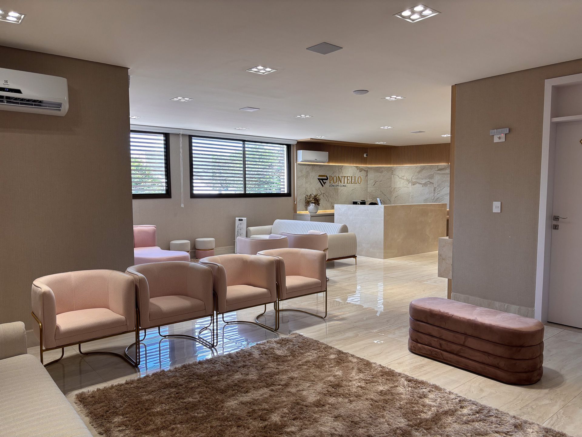 Uma sala de espera com muitas cadeiras e um tapete.