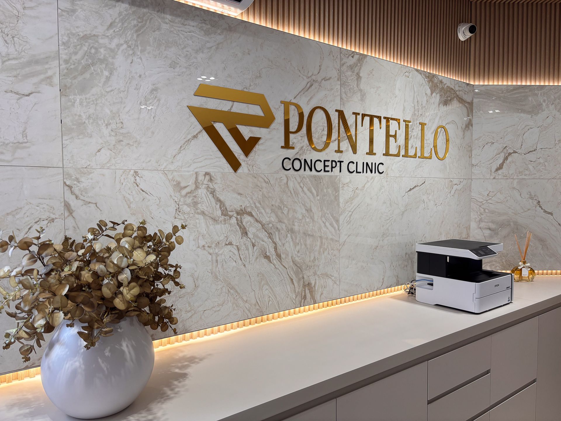 Uma placa da clínica conceito pontello está na parede acima de um balcão.