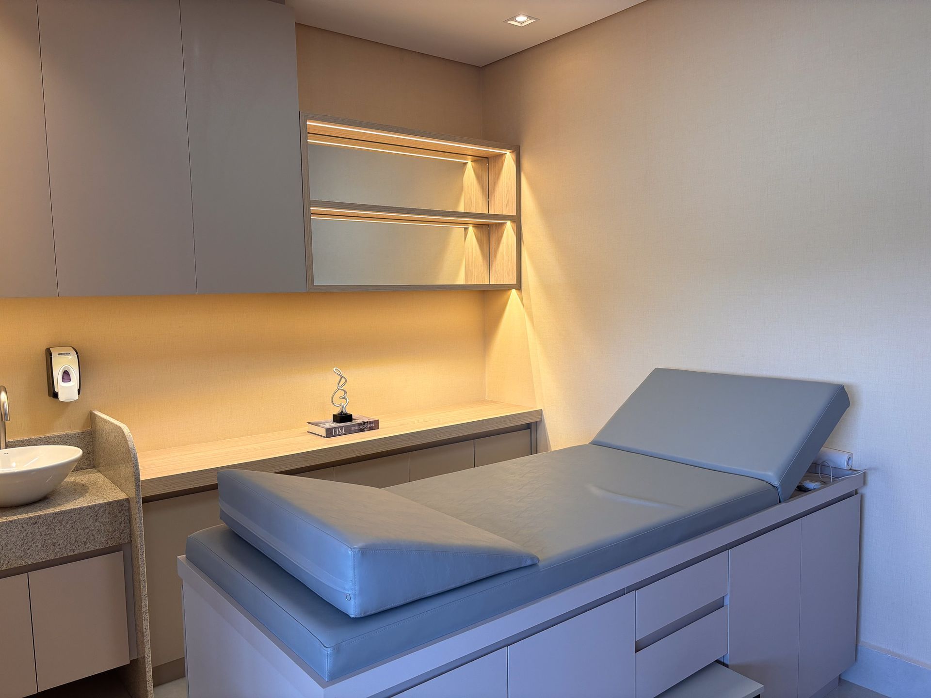 Um consultório médico com uma cama e uma pia.