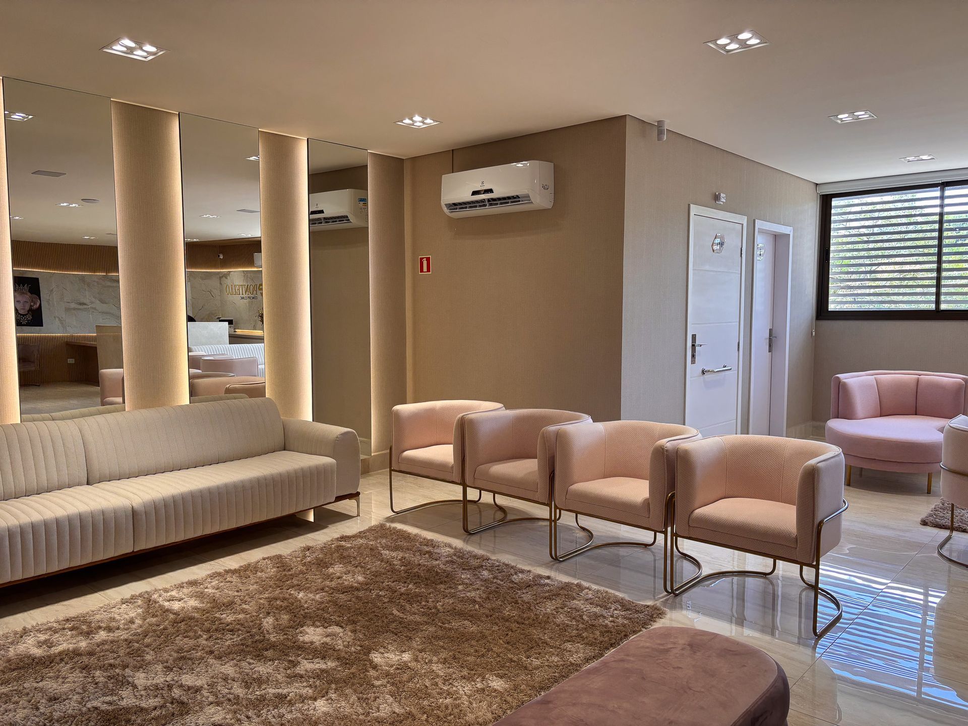 Uma sala de espera com um sofá, cadeiras e um tapete.