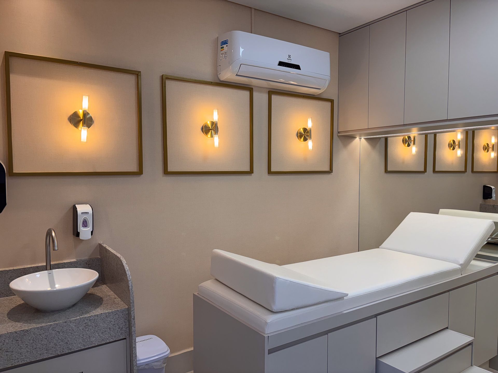 Um consultório médico com cama, pia e ar condicionado.