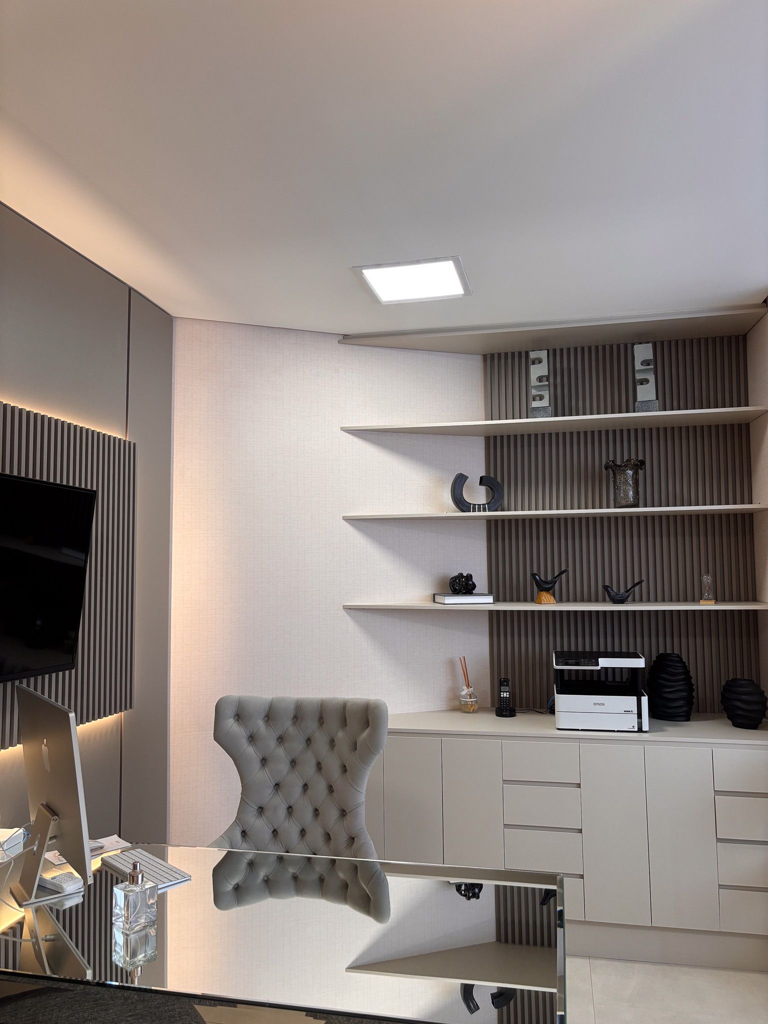 Uma sala com uma cadeira e uma tv na parede