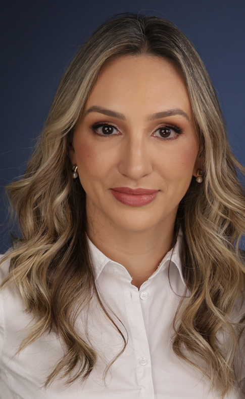 Uma mulher com longos cabelos loiros está vestindo uma camisa branca e brincos.