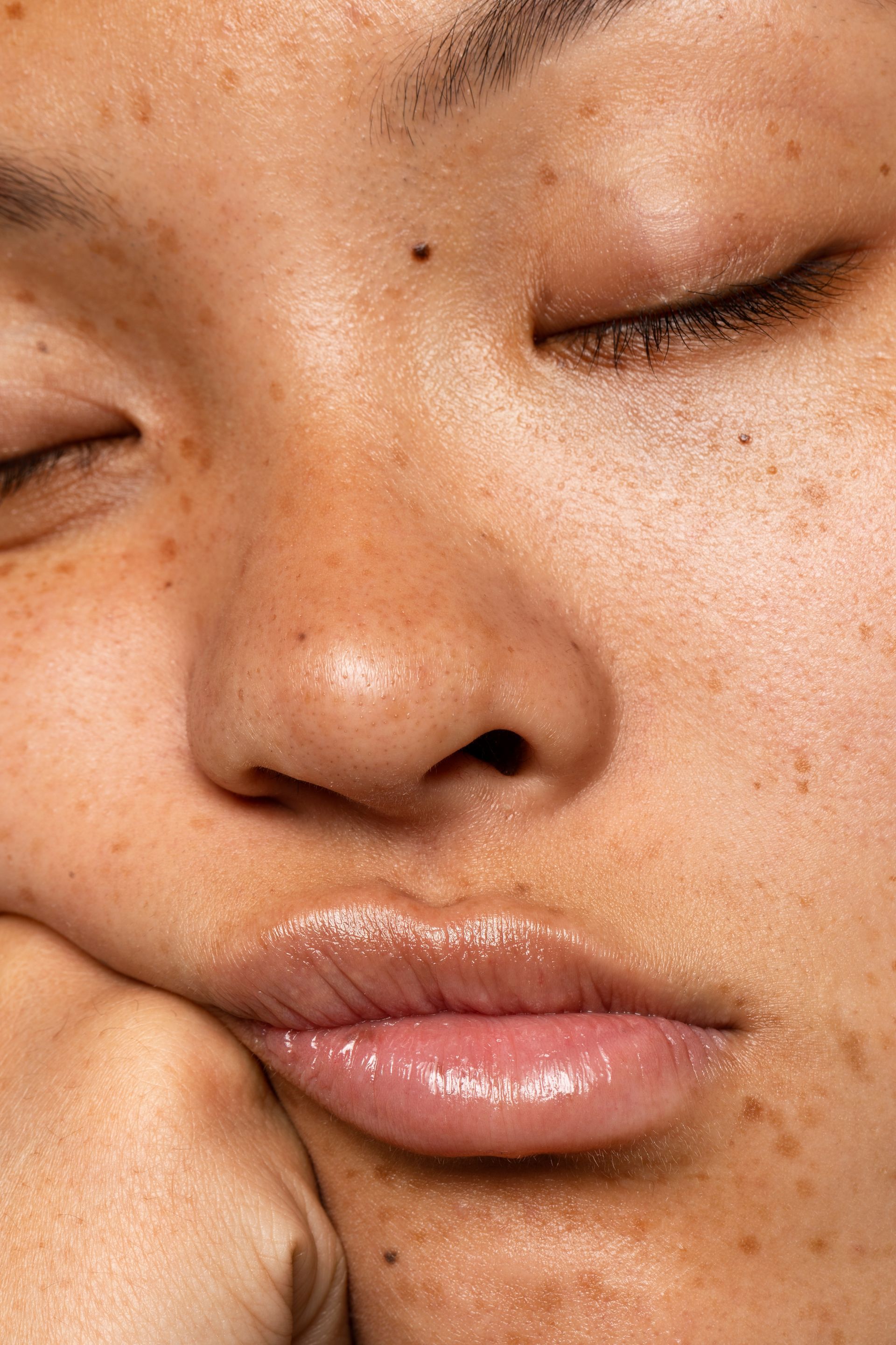 Um close do rosto de uma mulher com os olhos fechados.