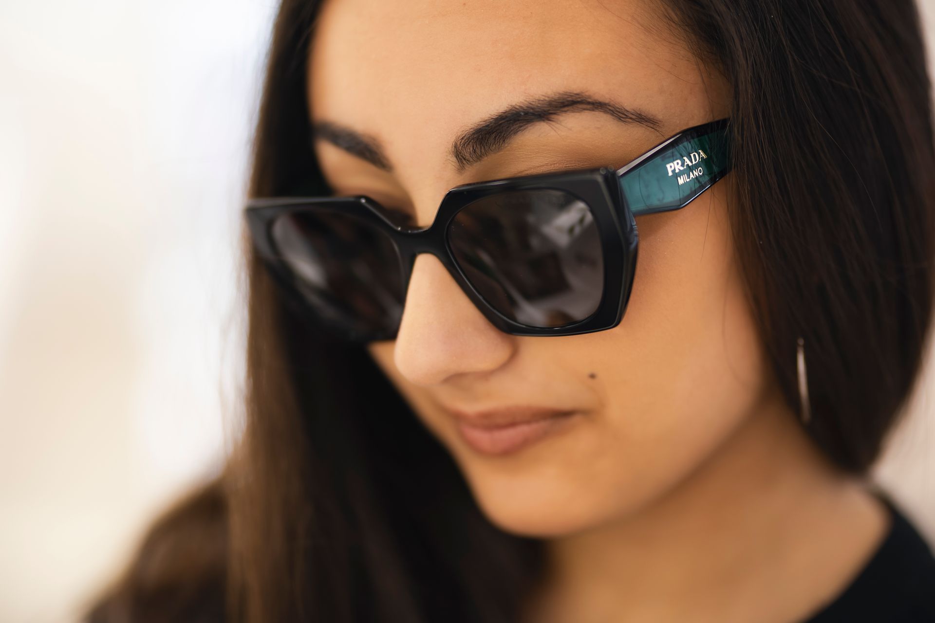 Un primo piano di una donna che indossa occhiali da sole