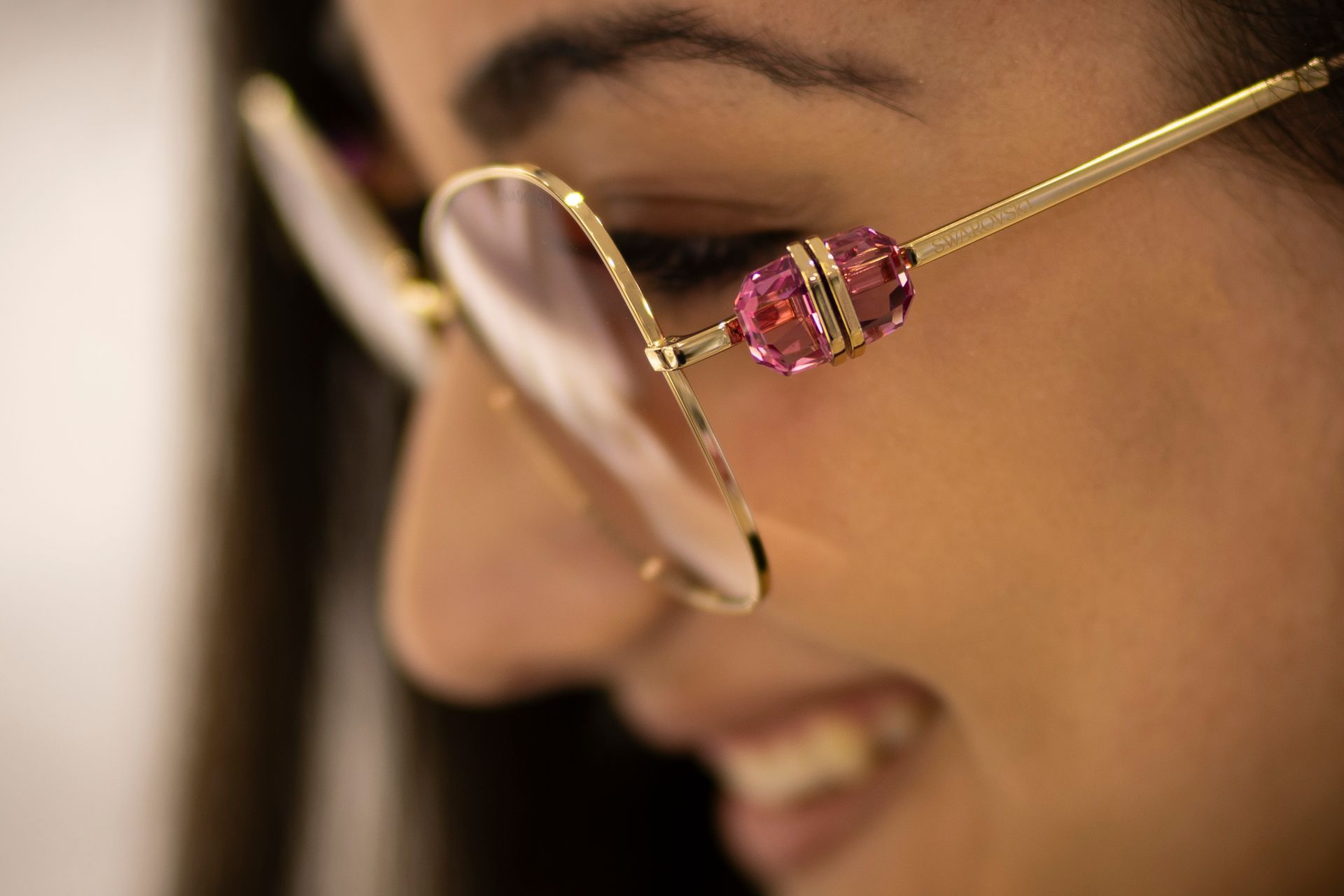 Un primo piano di una donna che indossa occhiali da sole e sorride