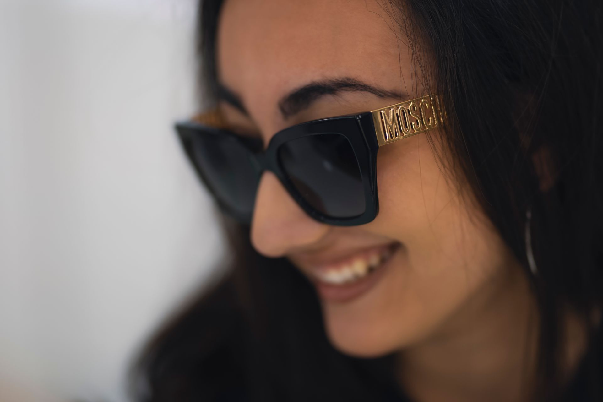 Primo piano di una donna che indossa occhiali da sole e sorride.