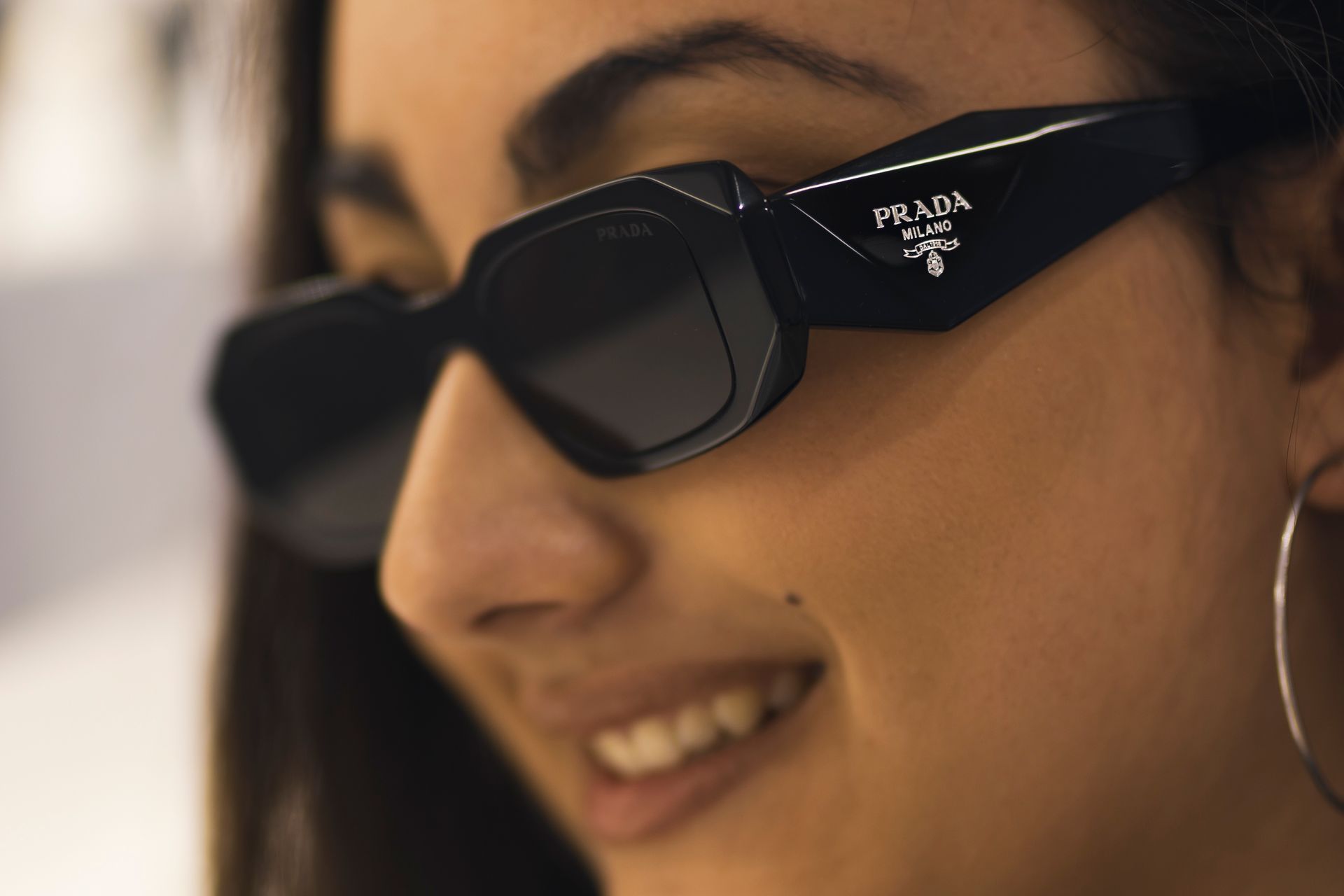 Un primo piano di una donna che indossa occhiali da sole prada