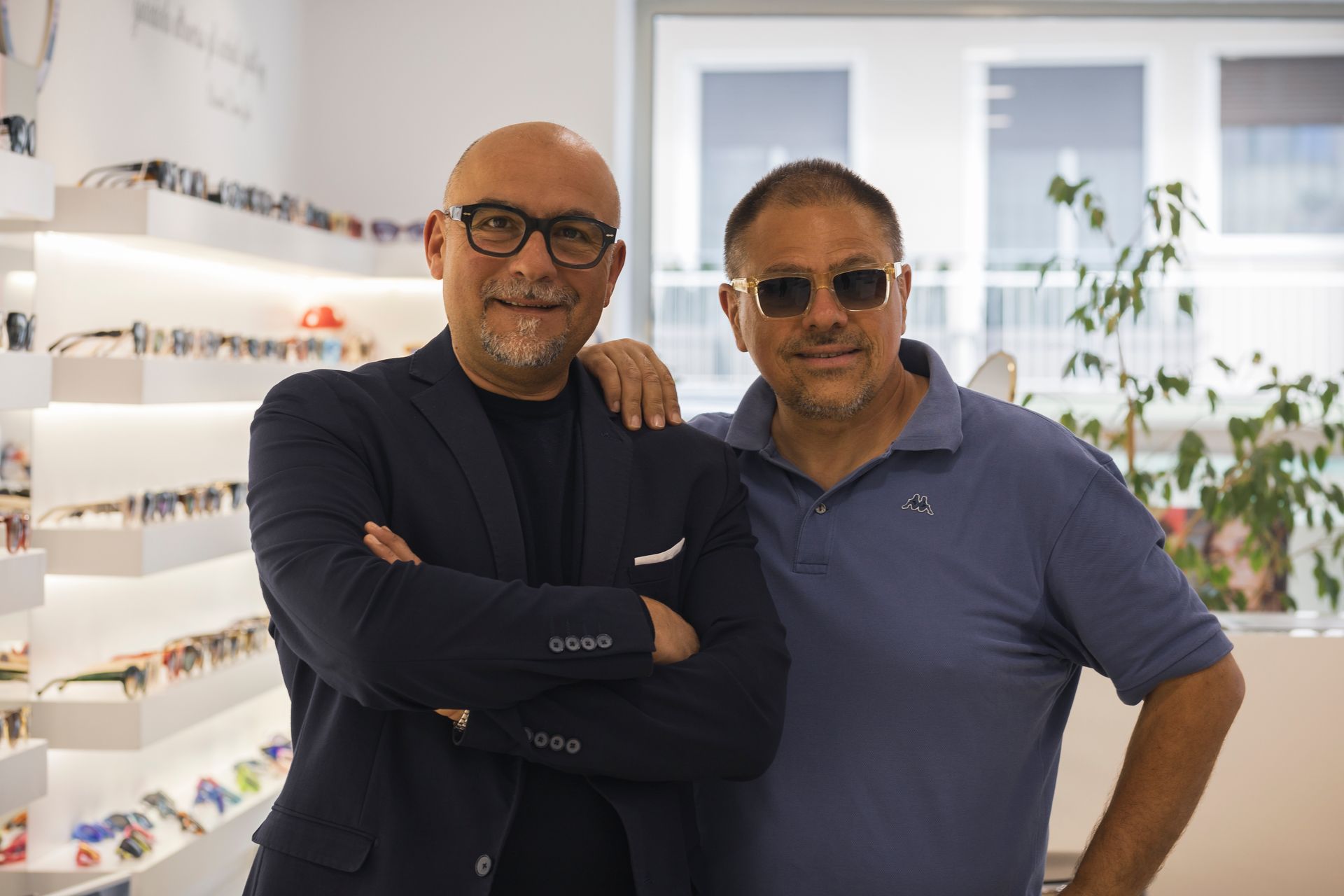 Due uomini sono in piedi uno accanto all'altro in un negozio di ottica.