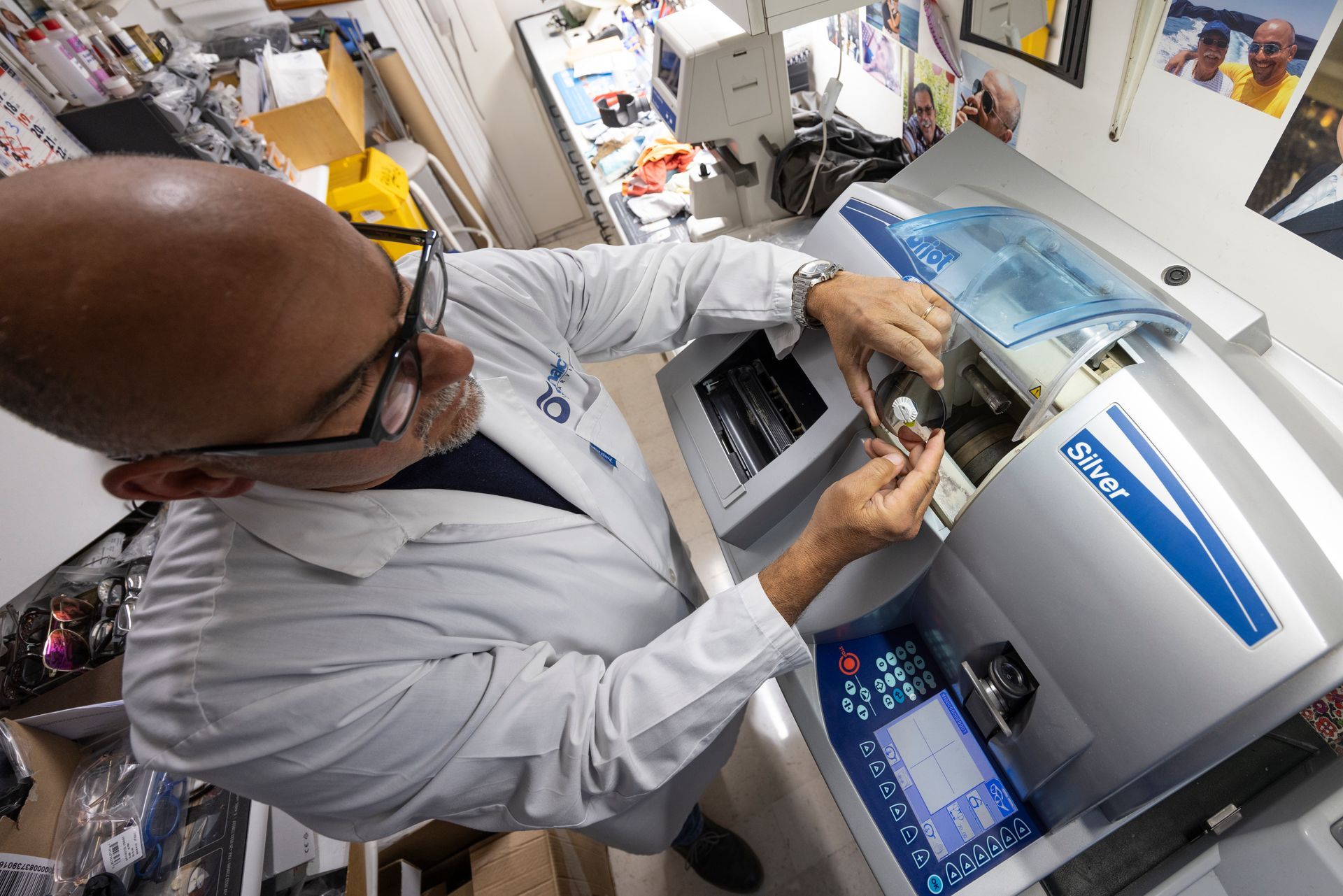 Un uomo in camice sta lavorando su una macchina.
