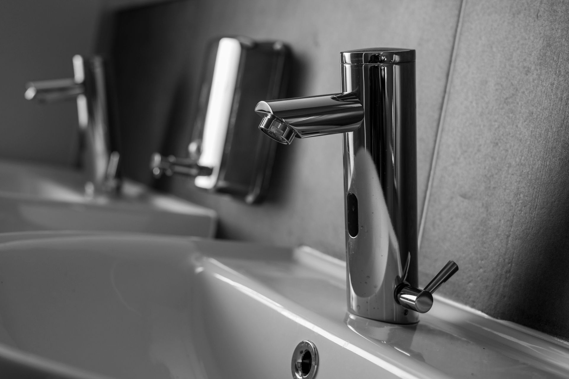 A black and white photo of a bathroom sink with a faucet on it.