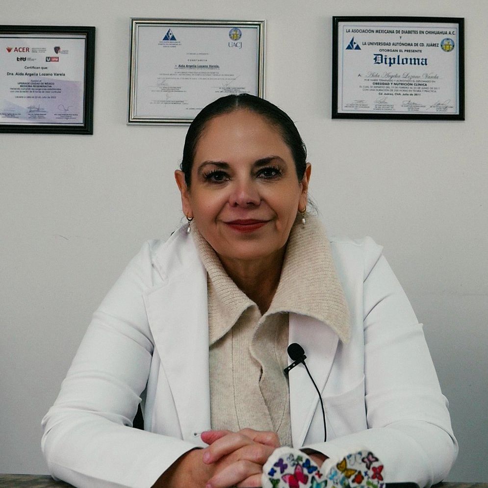 Dra. Aída Lozano, médico estético, en consulta con bata blanca y diplomas al fondo