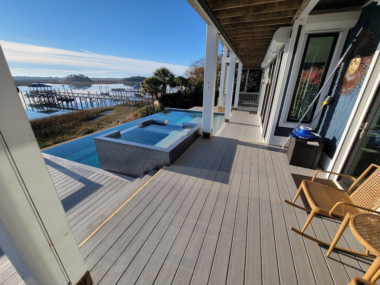 Custom deck construction in Porters Neck (Wilmington Area) NC using composite and wood materials around a pool and built in hot tub.