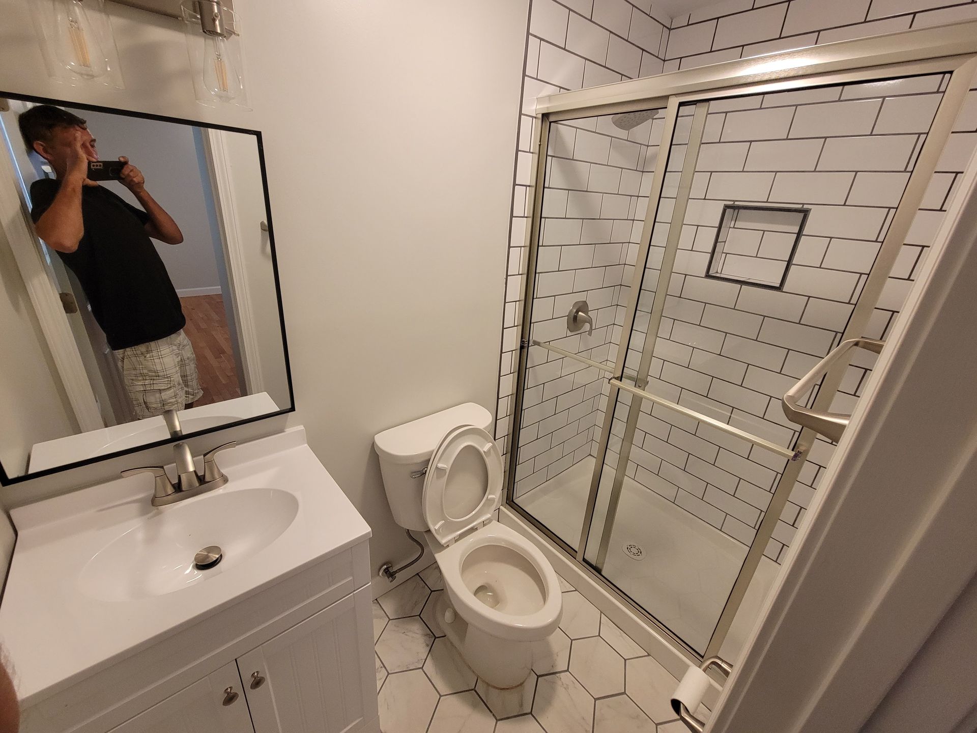 Bathroom remodeling in Wilmington NC featuring custom tile shower and vanity upgrade by Howard Roofing & Construction
