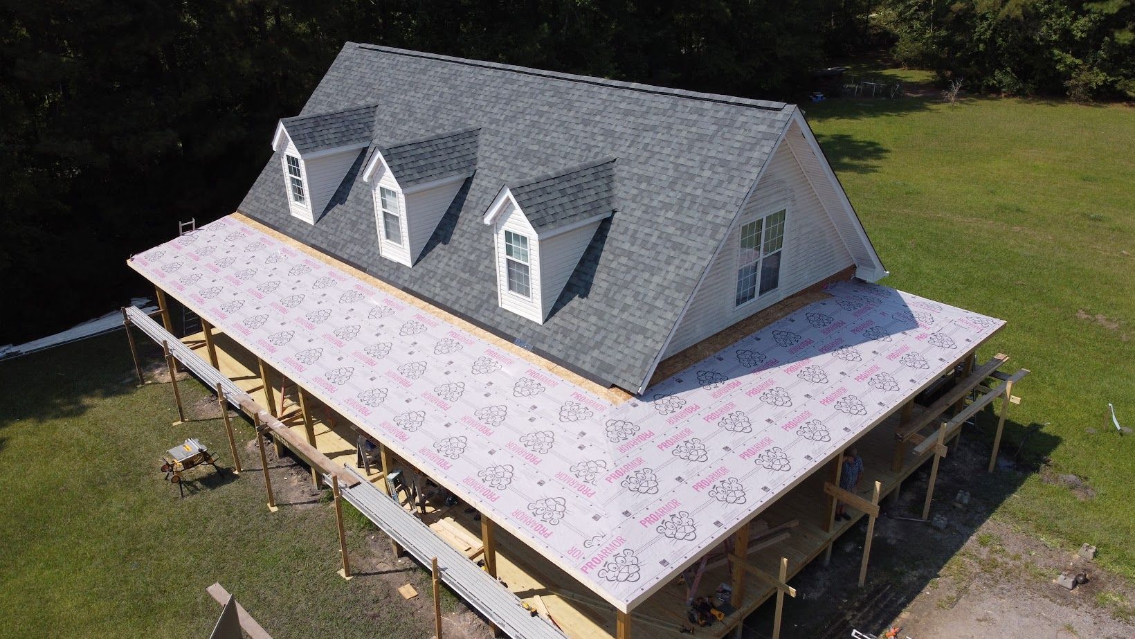An aerial view of a house under construction in a field.