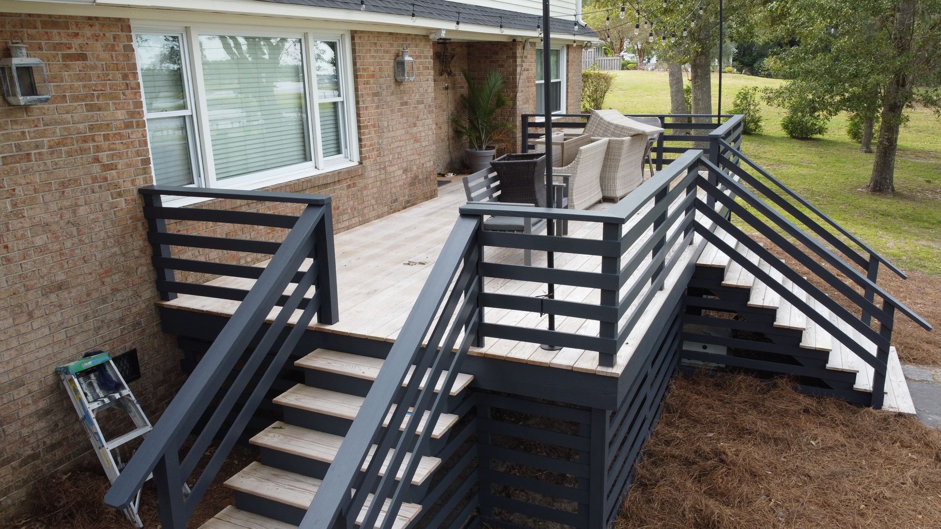 An aerial view of a large white house with a gray roof surrounded by trees.