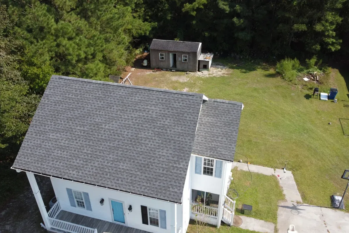 Shingle roof replacement Wilmington NC shown on a large multi-pitch home using GAF architectural shingles for long-term storm protection.