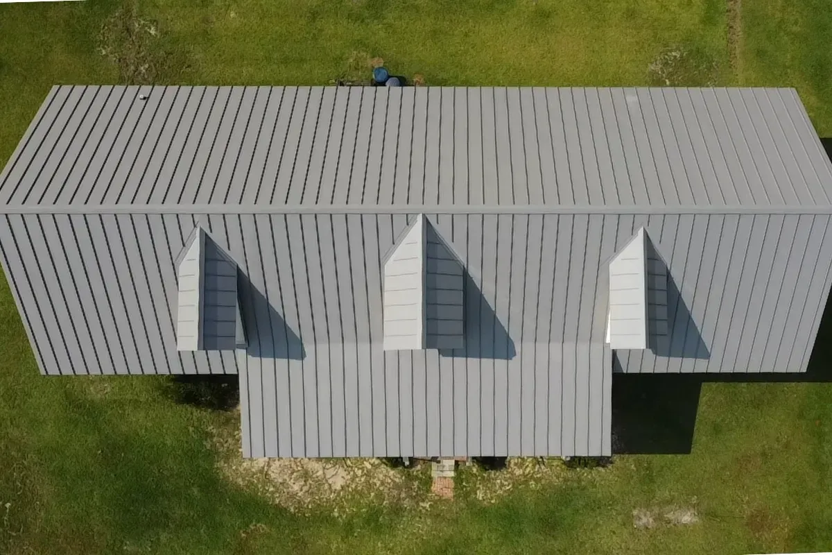 Drone image showing a completed 24-gauge double-lock standing seam metal roofing installation in Wilmington NC, with custom-fabricated panels, precision flashing, synthetic underlayment, and hurricane-ready detailing for maximum durability and coastal performance.