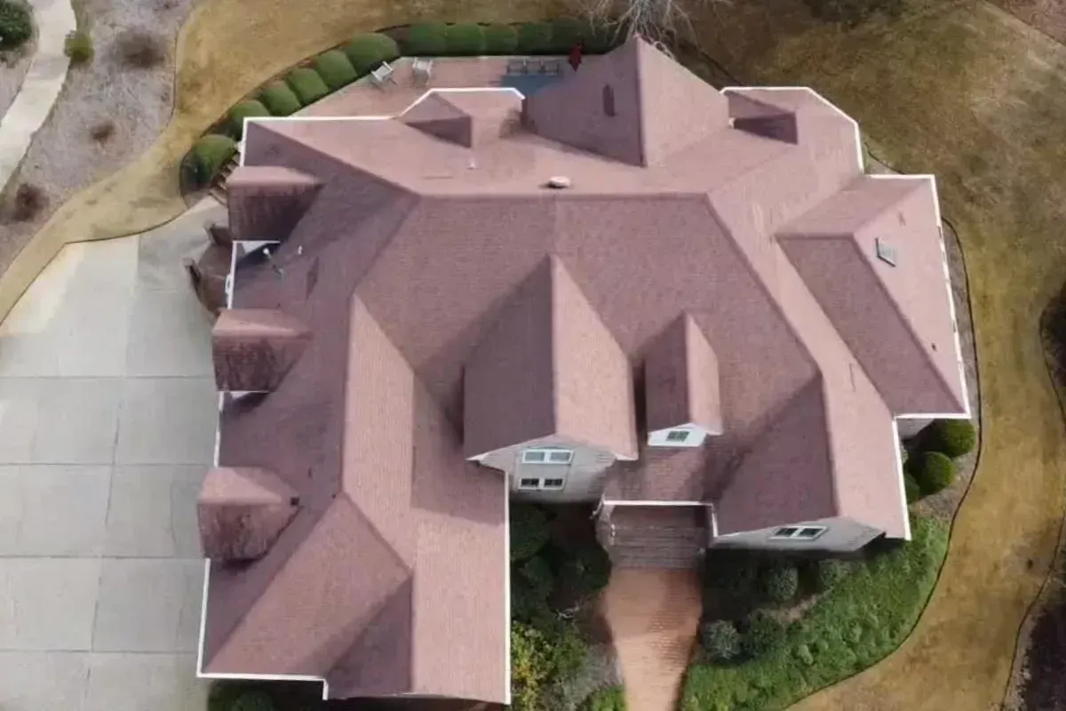  Before shingle roof replacement in Porters Neck Wilmington NC showing granule loss, lifted shingles, and early plywood deterioration on an aging architectural roof.
