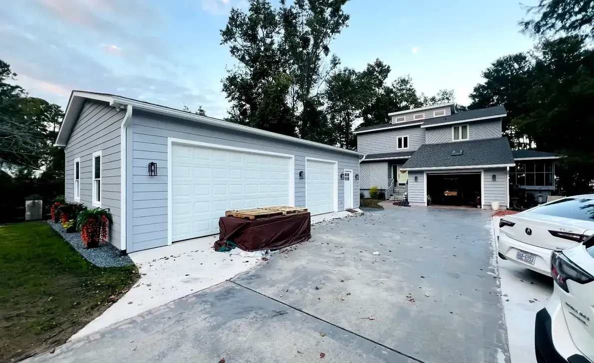 Completed detached garage with light blue siding and double garage doors in Coastal North Carolina