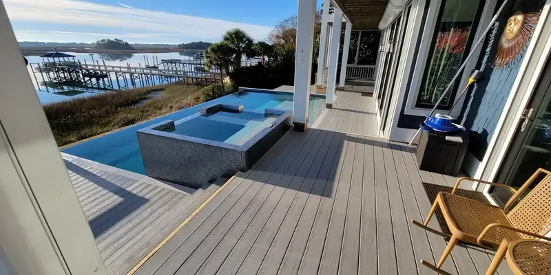 Composite deck beside pool and hot tub with clean finished edge and open outdoor space