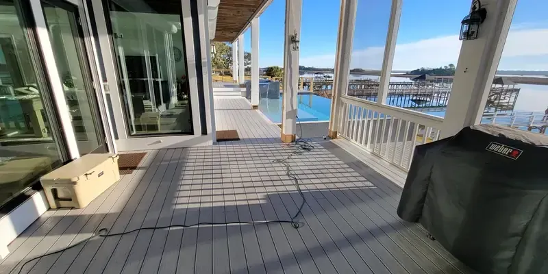 Composite deck walkway with water view and clean board layout along covered porch