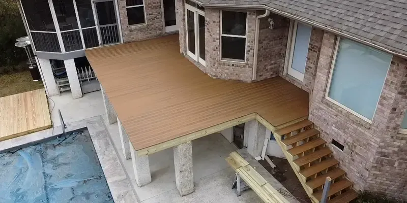 Composite duxxbak waterproof deck installation on brick home with stairs and clean finished edges