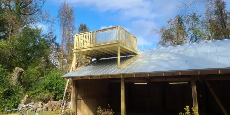 New garage/car barn with metal roof and elevated deck platform