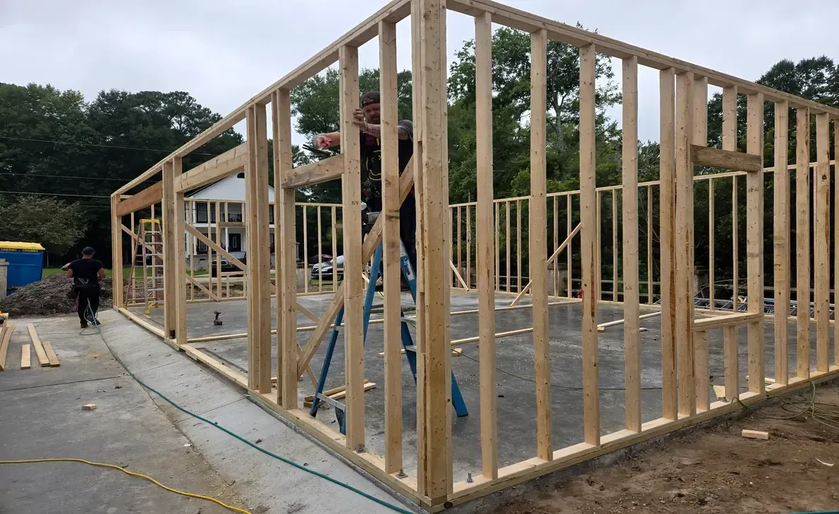 Garage build framing stage on concrete slab in Lake Waccamaw, NC with wall framing and door openings