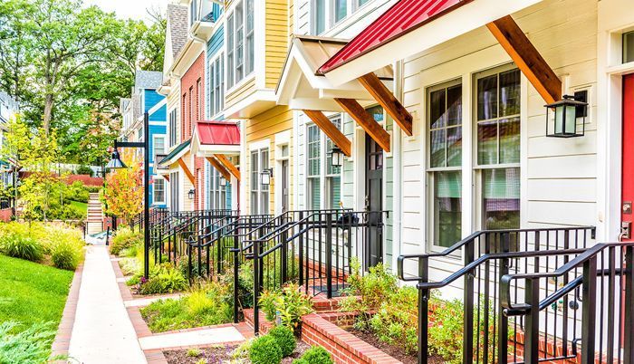 A row of colorful houses with a red door and a red roof. A row of colorful houses with a red door and a red roof.