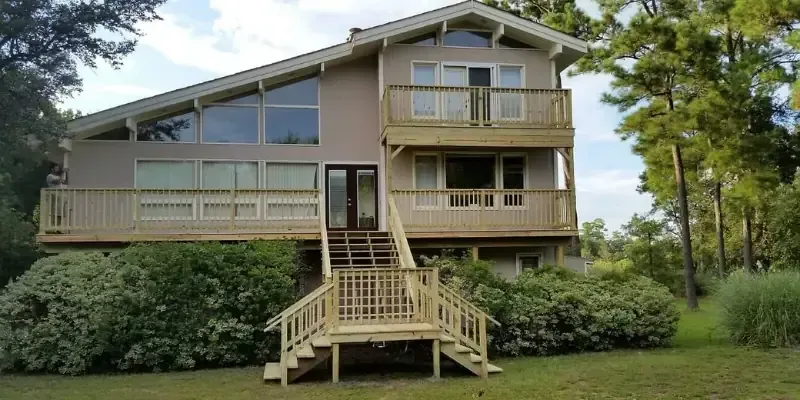 Multi-level wood deck with stairs and railings on coastal North Carolina home.
