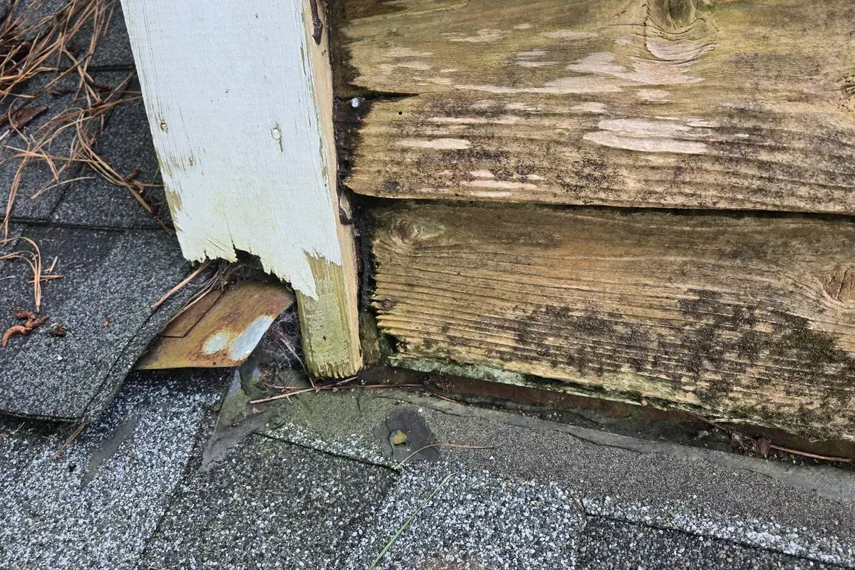 Water-damaged cedar siding and failing roof-to-wall flashing found during a Wilmington NC roof inspection.
