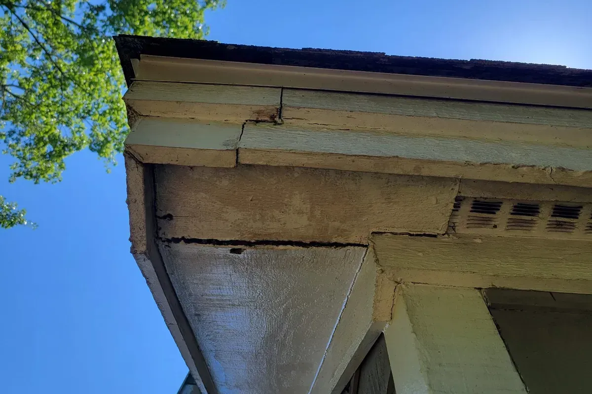 Moisture penetration from the roof above has caused the fascia and soffit to swell, separate, and crack. Previous patchwork repairs created weak points where water continued to intrude.
