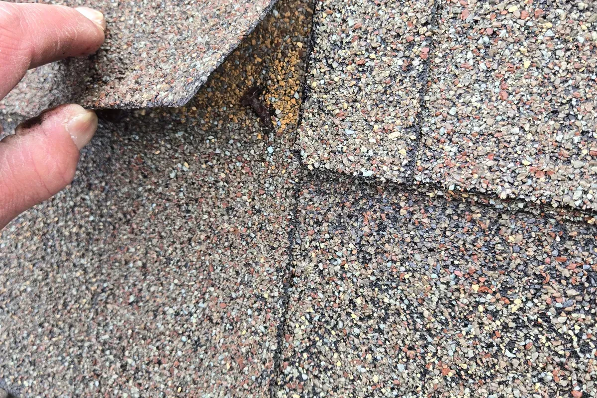 Nail pop lifting through shingle seam found during a roof inspection in Wilmington, NC.