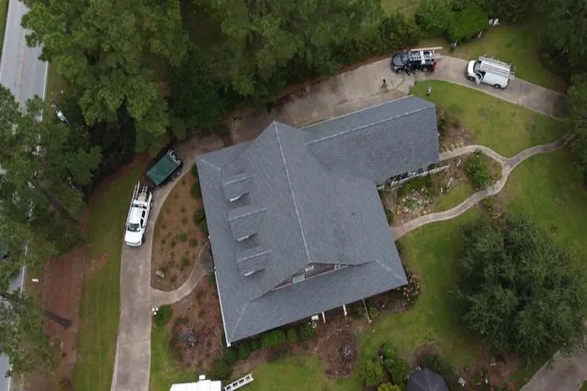 Architectural shingle roof with clean ridge cap installation.