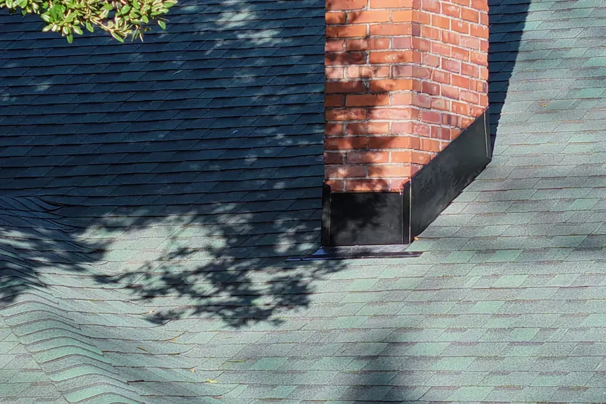 Roof flashing and chimney detail during roof replacement.