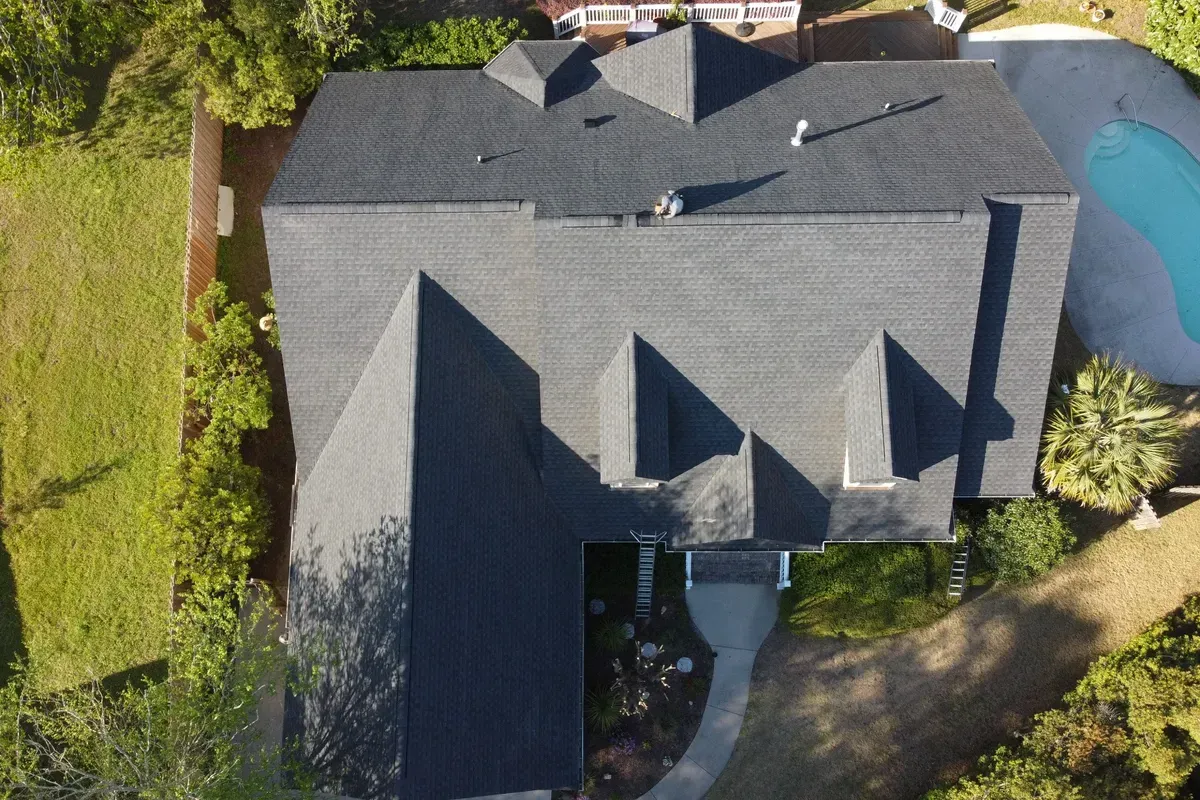 Shingle roofing contractors Wilmington NC installing new designer-blend shingles on a townhouse community roof system.