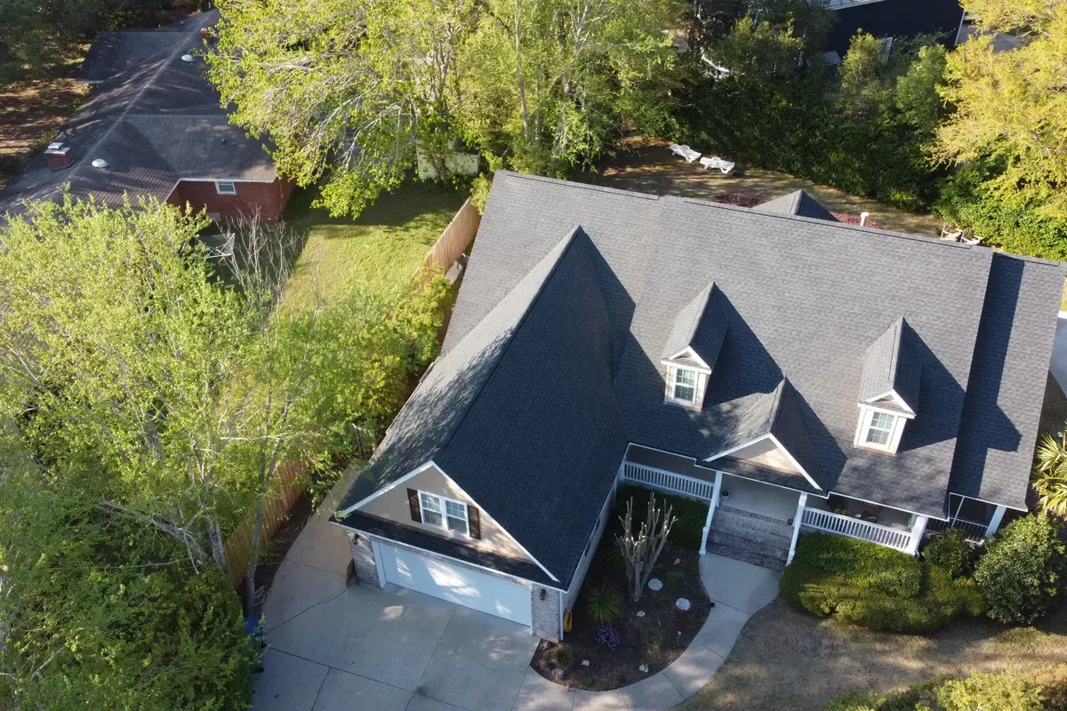 Certified shingle roofing contractors in Wilmington NC performing a full asphalt shingle roof installation on a large coastal home.