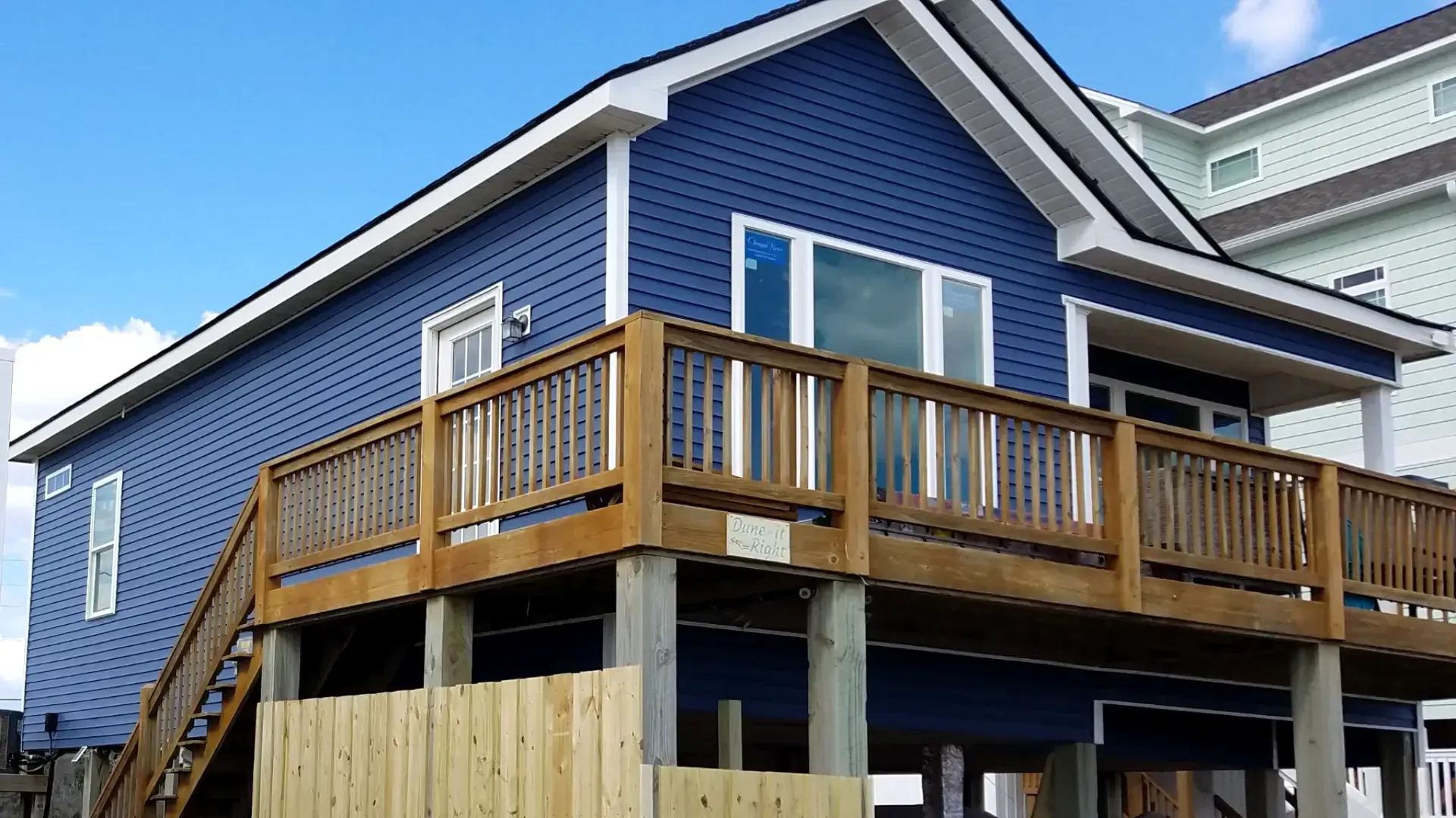Vinyl siding installation on coastal home in Topsail Beach NC with deck integration and new windows.
