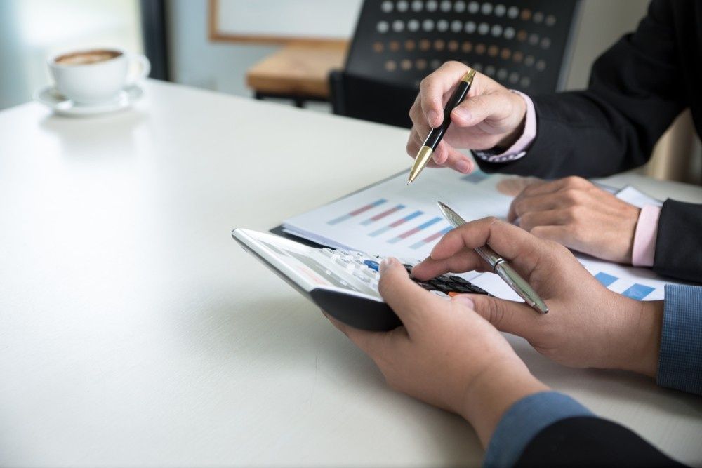 Two People Reviewing Financial Data with A Calculator and Pen — Books in a Mess Australia in Peats Ridge, NSW