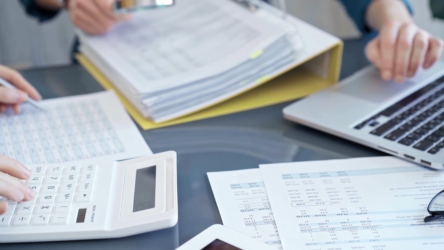 Hands Working with Documents, Calculator, Laptop, and Binder on A Desk — Books in a Mess Australia in Bateau Bay, NSW