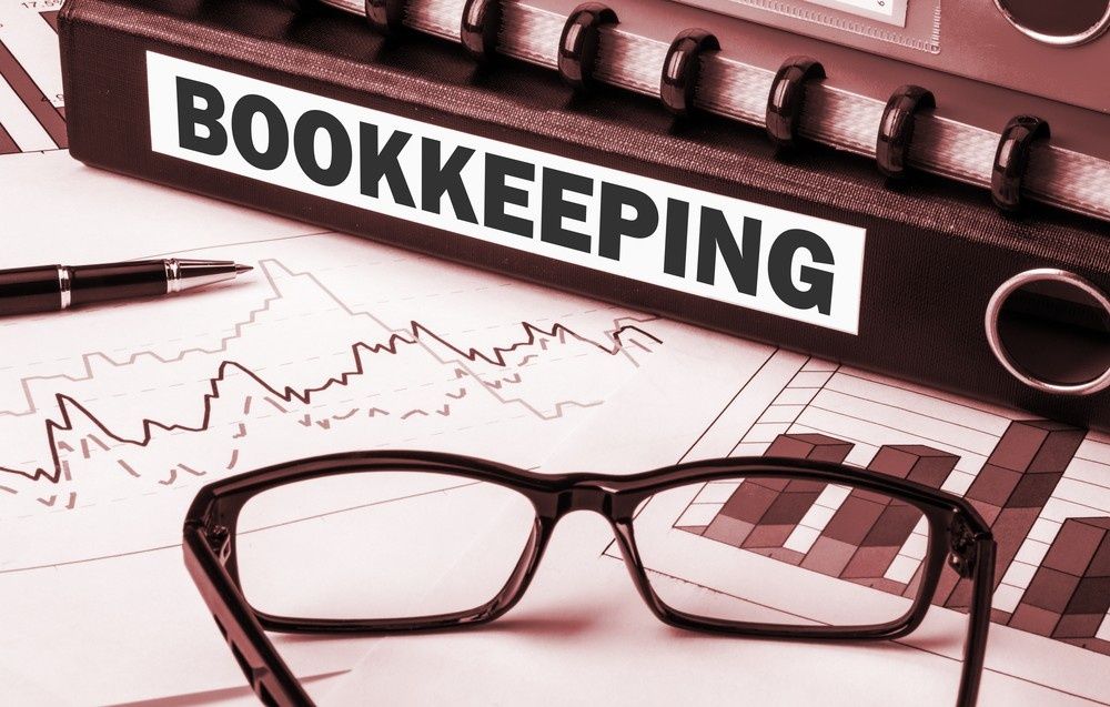 Bookkeeping Binder and Glasses on A Desk with Financial Charts and A Pen — Books in a Mess Australia in Woy Woy, NSW