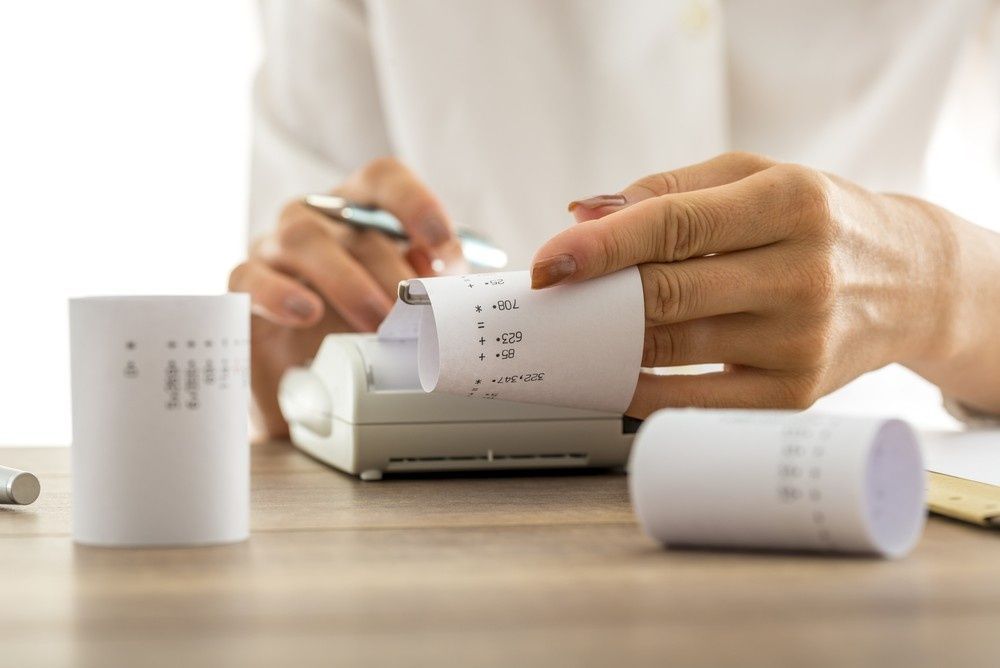 Person Using an Adding Machine, Reading a Paper Receipt, Light Setting — Books in a Mess Australia in Gosford, NSW
