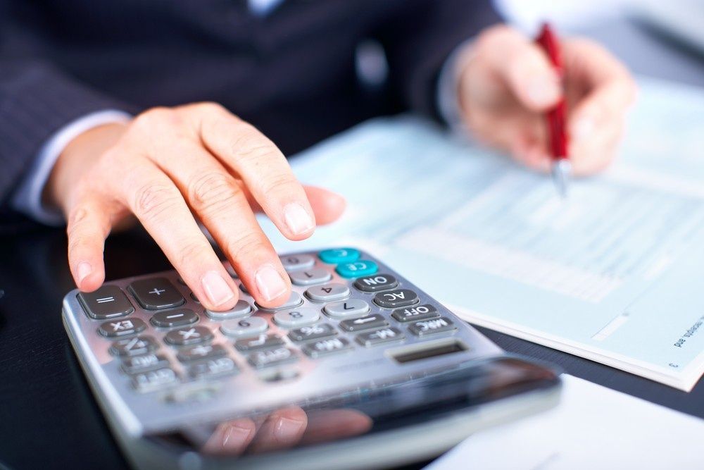 Person Using a Calculator and Pen on A Desk — Books in a Mess Australia in Bateau Bay, NSW