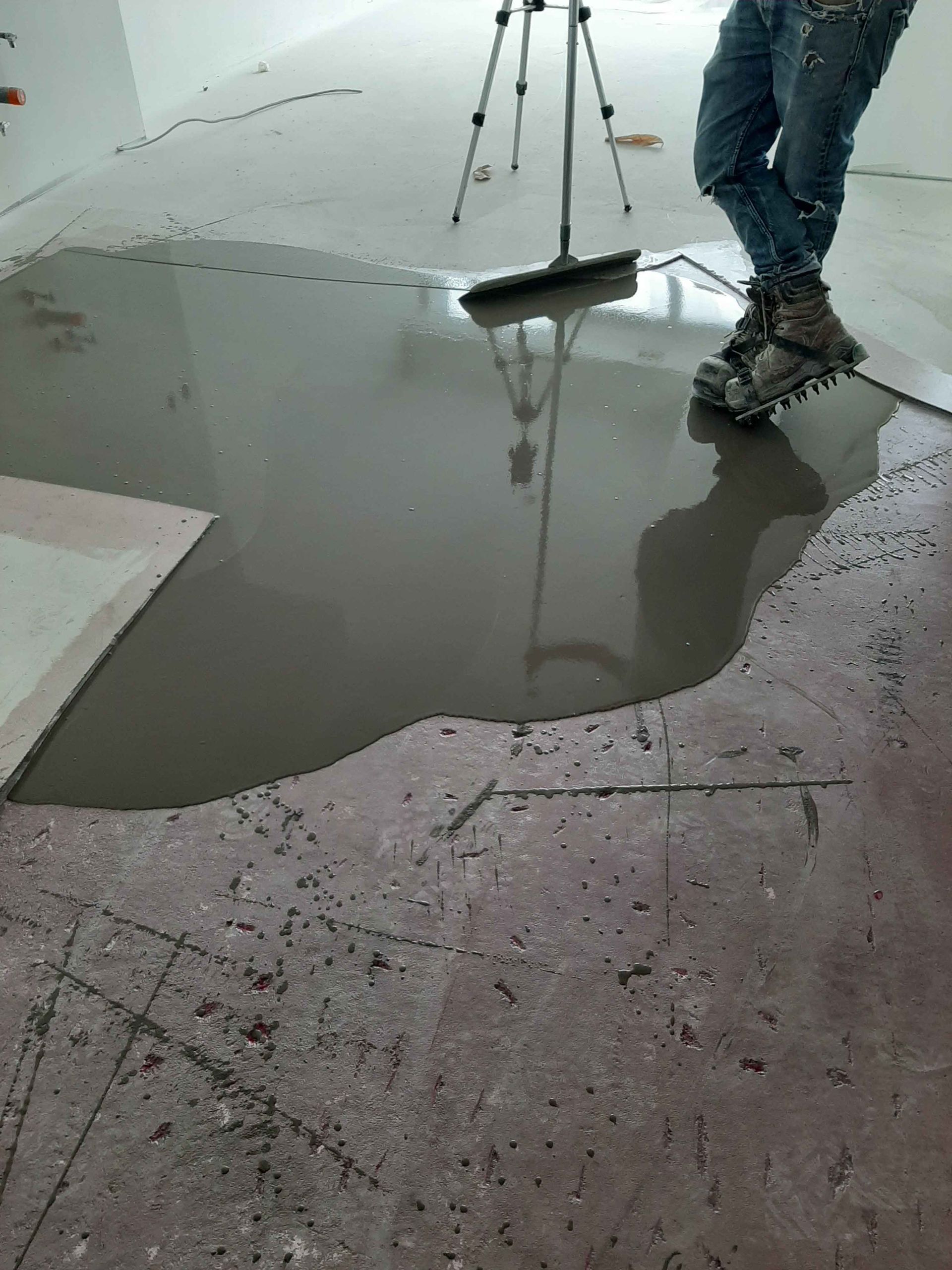 Une personne se tient debout dans une flaque de liquide sur le sol.