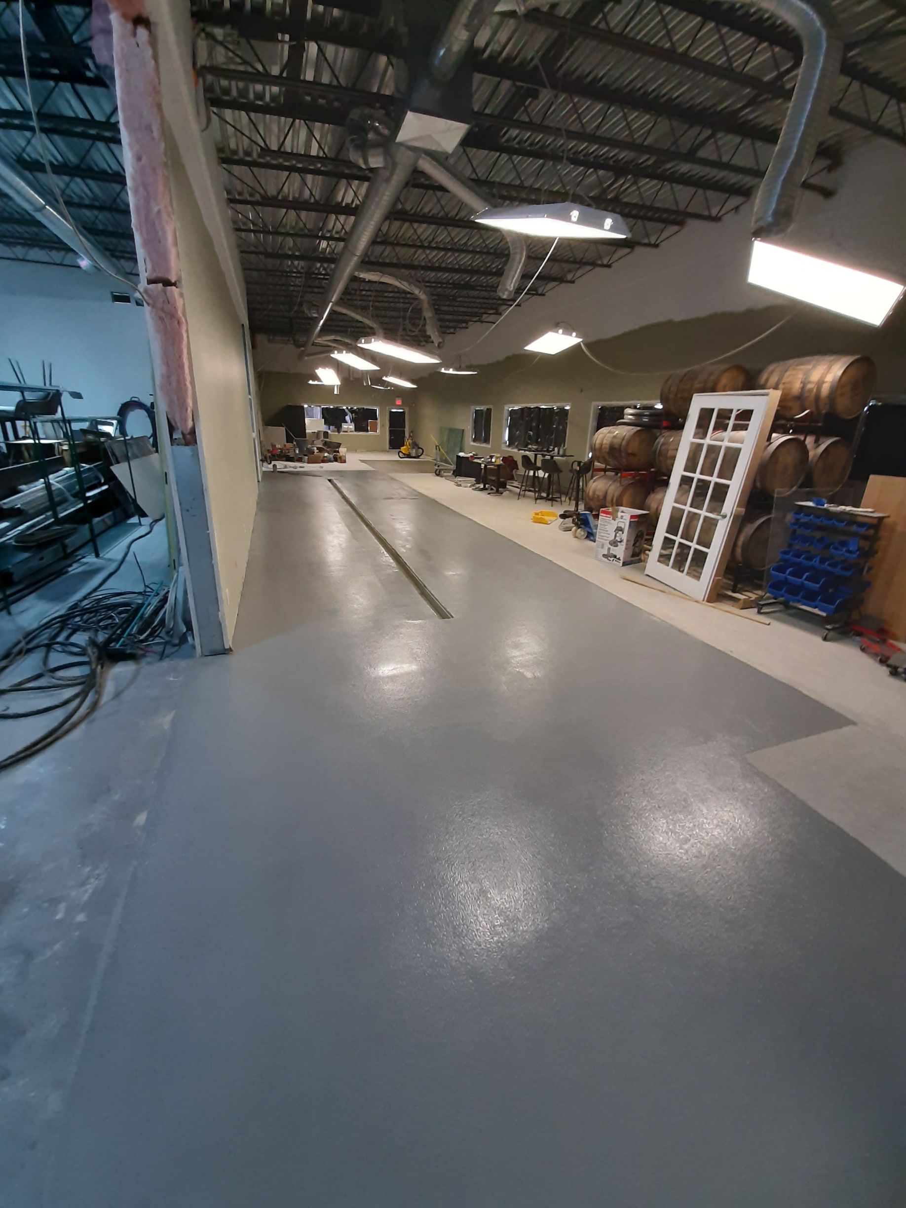 Une grande pièce avec un sol gris et beaucoup de meubles dedans.